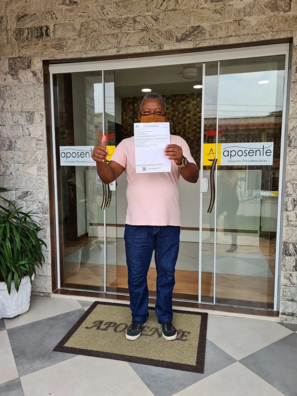 Cliente Nobre e Frazão Aposente na fachada do escritório com documento