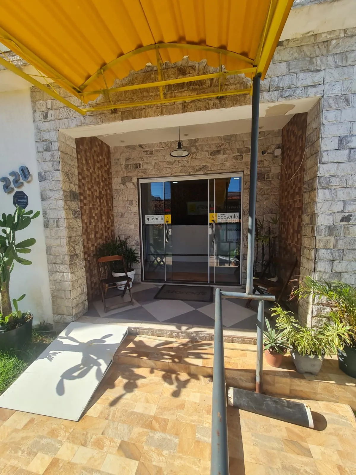 Entrada do escritório Nobre e Frazão Aposente com toldo amarelo