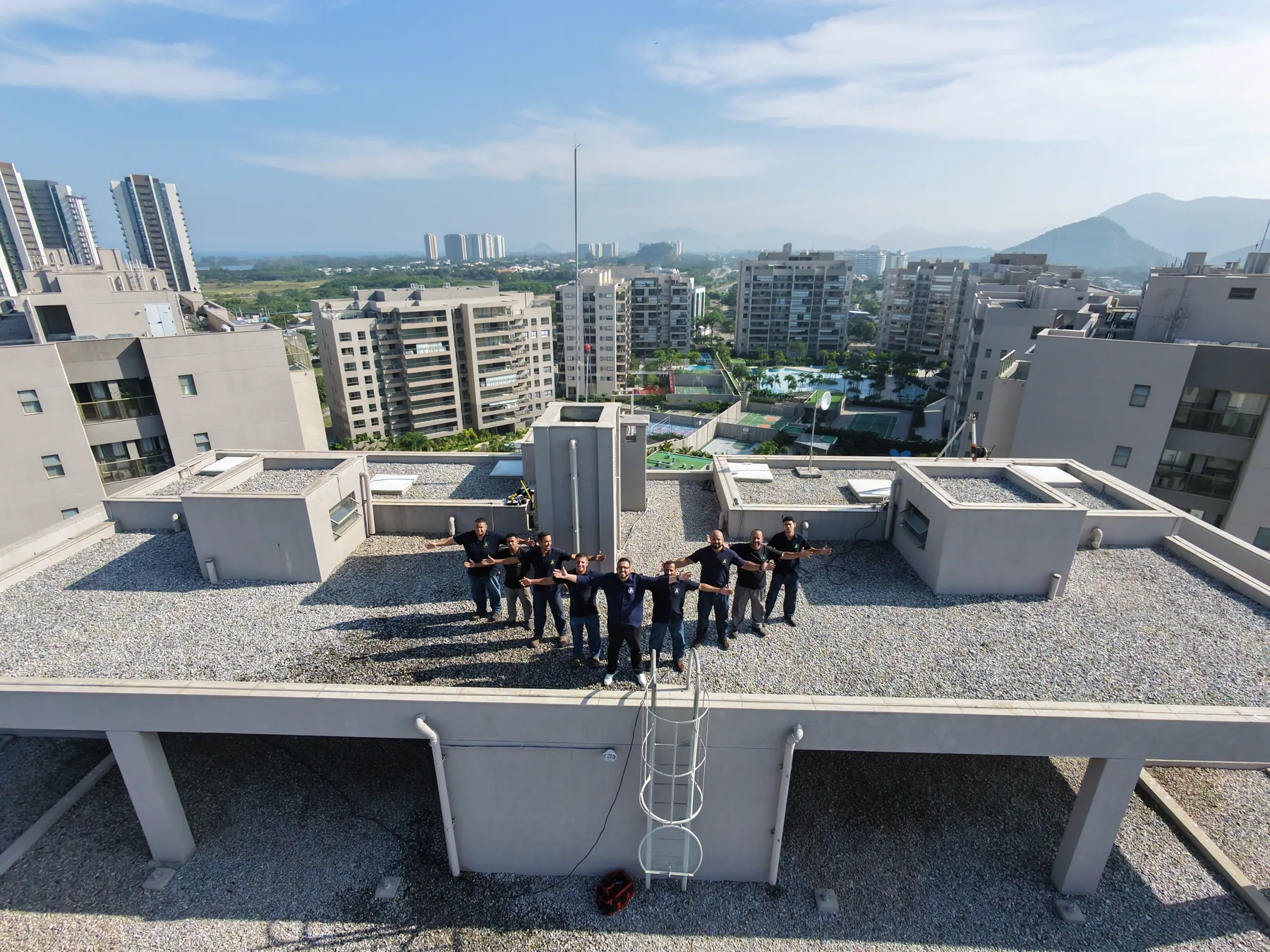 Equipe da Atlantic Soluções Ambientais vista de cima na cobertura de um condomínio no Rio de Janeiro