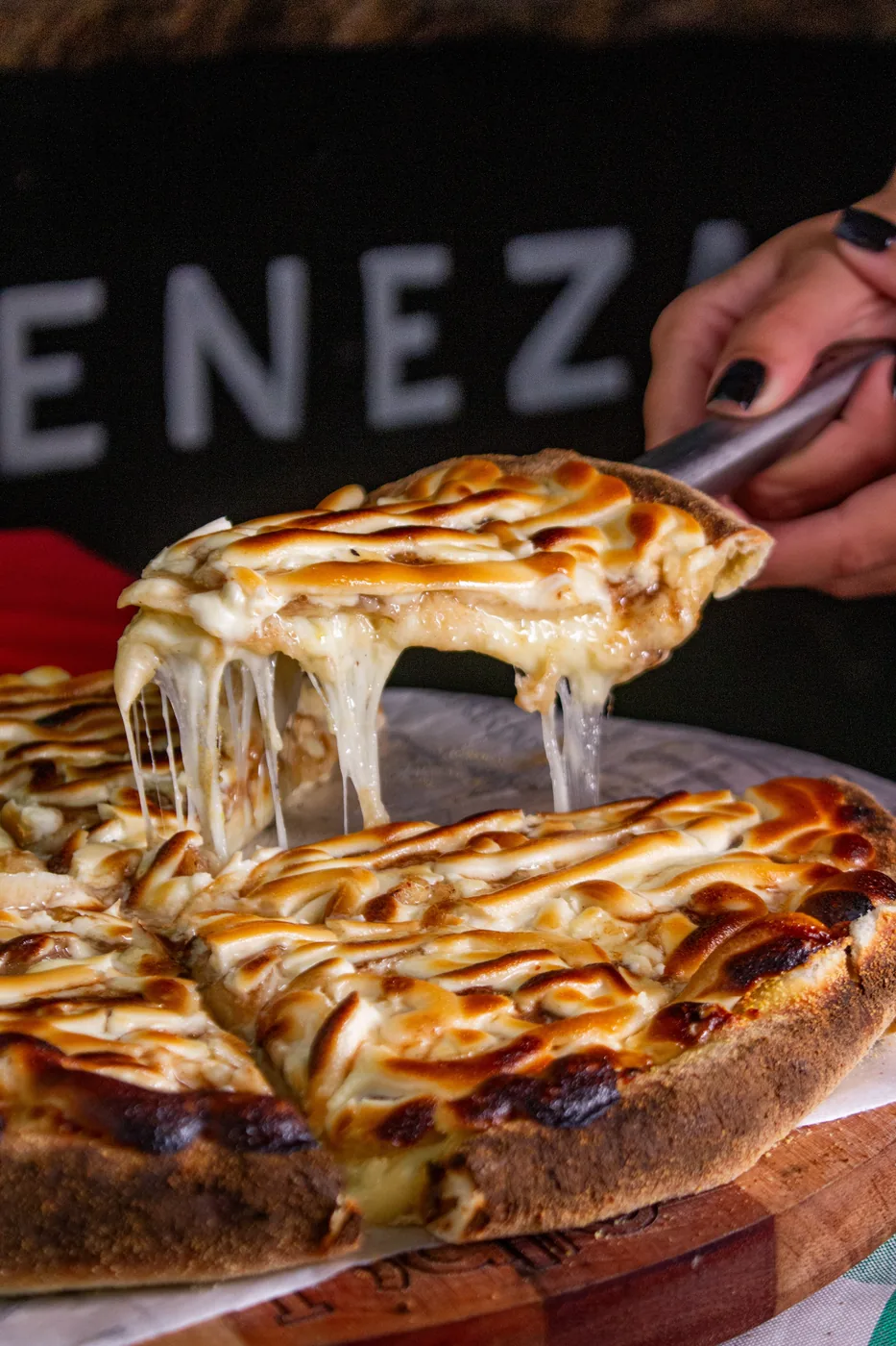 Fatia de pizza da Casa Piatto com queijo derretido puxando