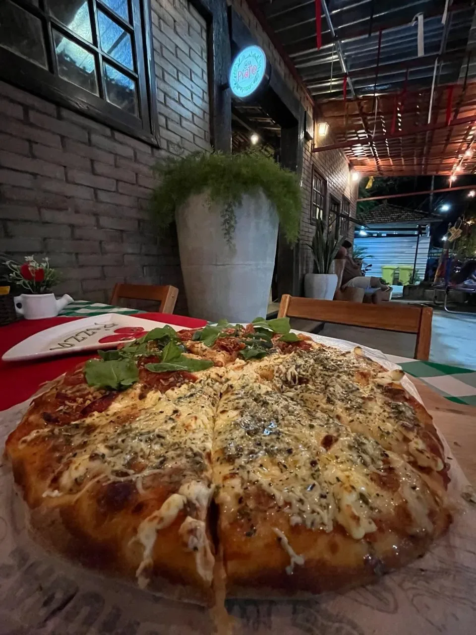 Pizza inteira servida na mesa da Casa Piatto