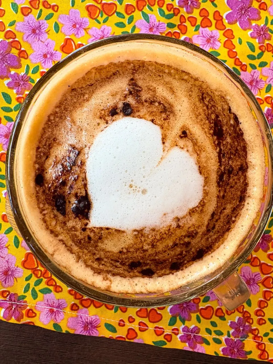 Cappuccino com desenho de coração na espuma servido na mesa