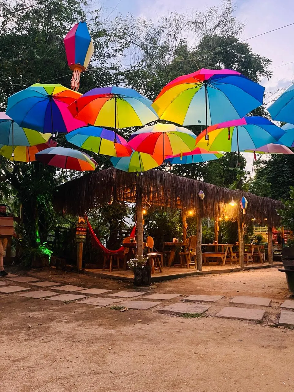 Quiosque de sapé sob guarda-chuvas coloridos à noite