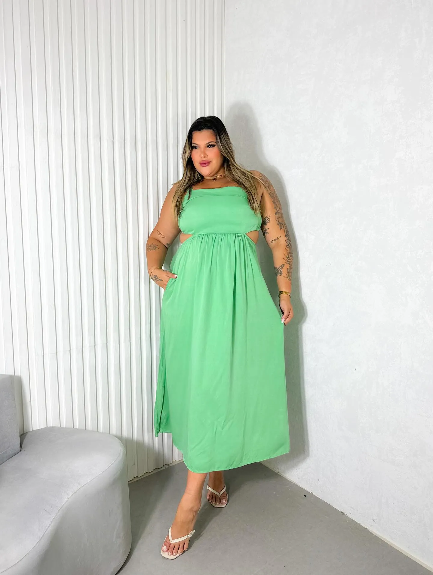 Modelo plus size usando vestido midi verde com recortes da Madame Luxo