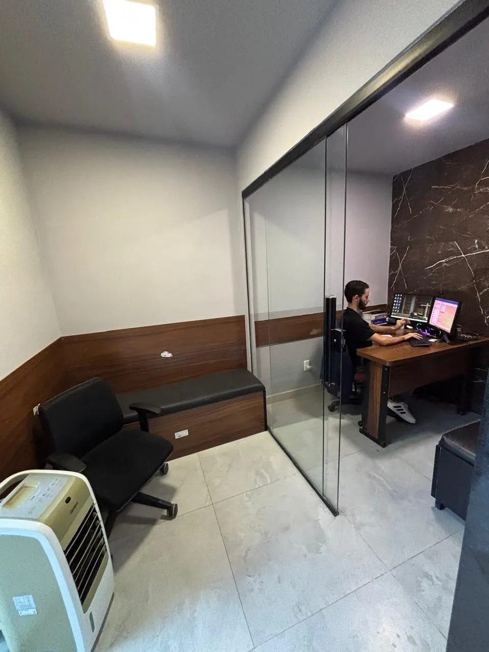Sala de atendimento com divisória de vidro no escritório Pereira Advocacia